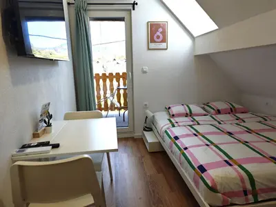 a bedroom with a bed and a desk and a window at Slovenian House Mira in Zgornje Gorje