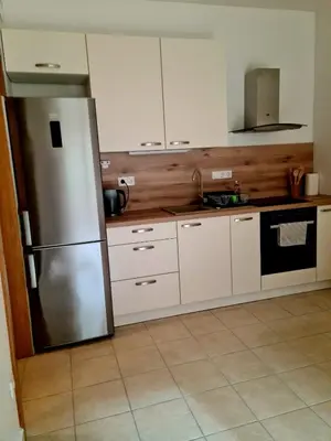 a kitchen with white cabinets and a stainless steel refrigerator at Woodstone 6 in Pekre