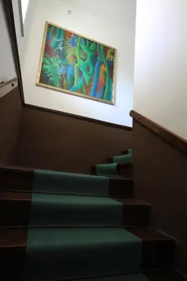a painting hanging on the wall above some stairs at Hostel Vrba in Ljubljana