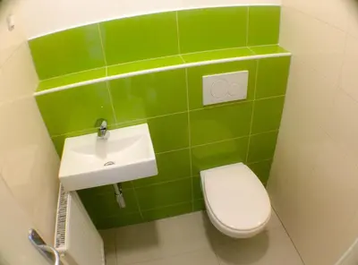 a green bathroom with a toilet and a sink at Hostel Vrba in Ljubljana