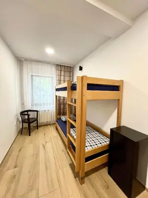 a room with two bunk beds and a table at Hostel Vrba in Ljubljana