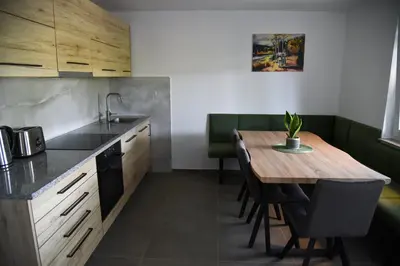 a kitchen with a table and a sink and a table and chairs at Mala Vila Kolpa in Griblje
