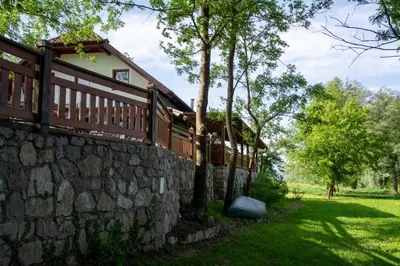a stone retaining wall next to a house at Mala Vila Kolpa in Griblje