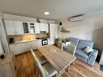 a kitchen and living room with a table and a couch at Cozy Corner Ljubljana in Ljubljana