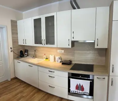 a kitchen with white cabinets and a stove top oven at Cozy Corner Ljubljana in Ljubljana