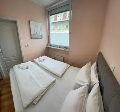 a room with two beds and a window at Cozy Corner Ljubljana in Ljubljana