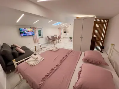 a bedroom with a large pink bed and a couch at APP Krofek in Zgornje Škofije