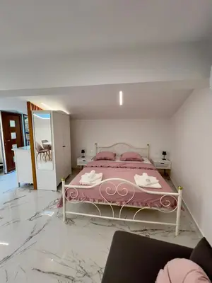 a bedroom with a pink bed and a mirror at APP Krofek in Zgornje Škofije