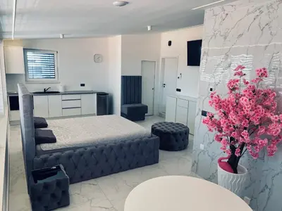 a bedroom with a bed and a table and a kitchen at ApartmaSLB in Slovenska Bistrica