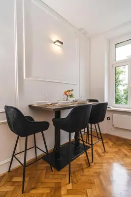 a dining room with a table and four chairs at HL Apartments in Maribor
