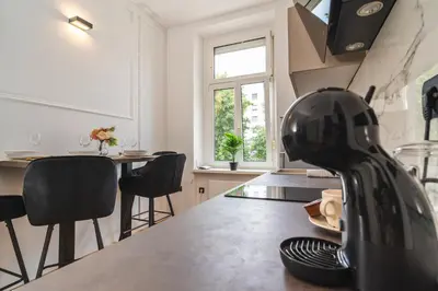 a kitchen with a counter and a table with chairs at HL Apartments in Maribor