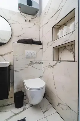 a white bathroom with a toilet and a sink at HL Apartments in Maribor