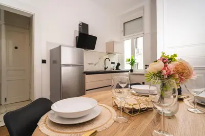 a kitchen with a table with plates and flowers on it at HL Apartments in Maribor