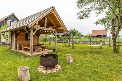a log cabin with a hammock and a playground at Kolpa Holidays in Gradac