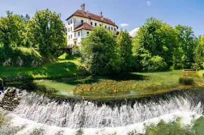 a waterfall in front of a house and a river at Kolpa Holidays in Gradac