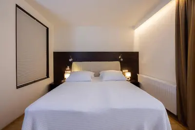 a bedroom with a white bed with two white pillows at Rooms Bella in Bled
