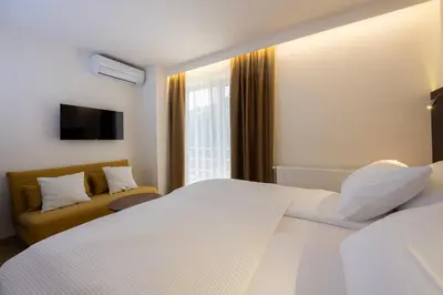 a bedroom with a large white bed and a couch at Rooms Bella in Bled