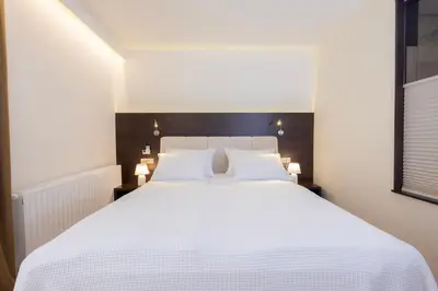 a bedroom with a large white bed with two white pillows at Rooms Bella in Bled
