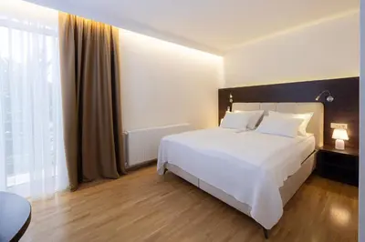 a bedroom with a white bed and a large window at Rooms Bella in Bled
