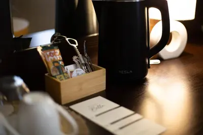 a black coffee mug sitting on a table with a wooden holder at Rooms Bella in Bled