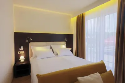 a bedroom with a large bed and a large window at Rooms Bella in Bled