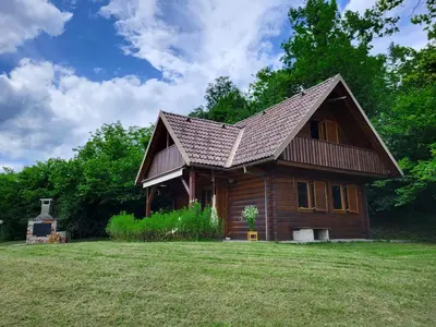 a log cabin with a roof on a grass field at Hillside Cottage in Bled