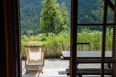 a room with a view of a table and a chair at Hillside Cottage in Bled