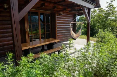 a hammock hanging from the side of a cabin at Hillside Cottage in Bled