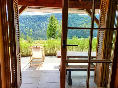a door to a porch with a view of a chair at Hillside Cottage in Bled
