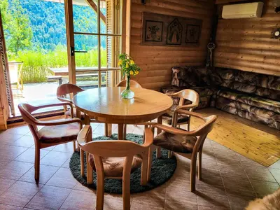 a dining room with a wooden table and chairs at Hillside Cottage in Bled