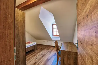 an attic room with a table and a window at Apartments Metro 7 in Ljubljana