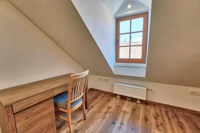 a attic room with a desk and a window at Apartments Metro 7 in Ljubljana