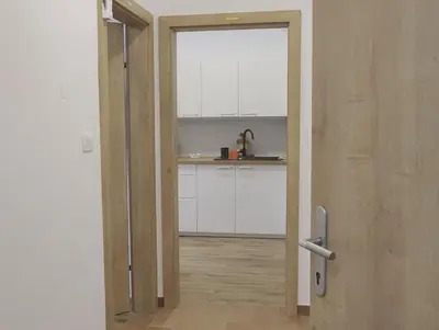 an open door to a kitchen with white cabinets at Apartments Metro 7 in Ljubljana