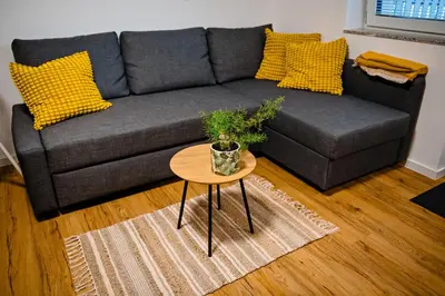 a living room with a gray couch and a table at Apartment METULJ in Domžale