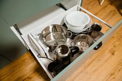 a stove top with pots and pans in a drawer at Apartment METULJ in Domžale