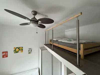 a bedroom with a bed and a ceiling fan at Beerpartment with parking in Ljubljana