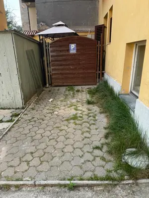 an entrance to a building with an umbrella and grass at Beerpartment with parking in Ljubljana