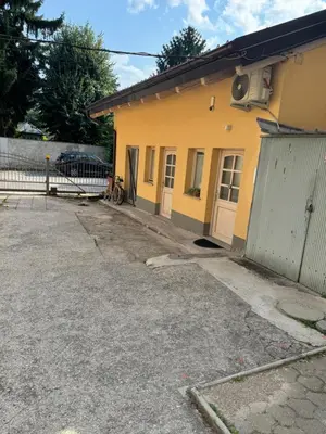 a yellow house with a gate and a driveway at Beerpartment with parking in Ljubljana