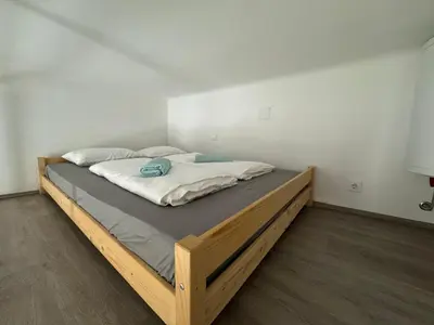 a bedroom with a large bed with a wooden frame at Beerpartment with parking in Ljubljana