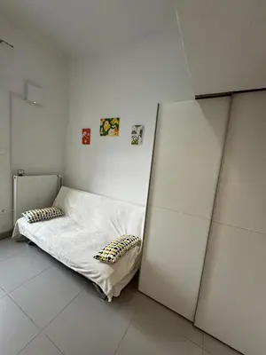 a white room with a bed in the corner at Beerpartment with parking in Ljubljana