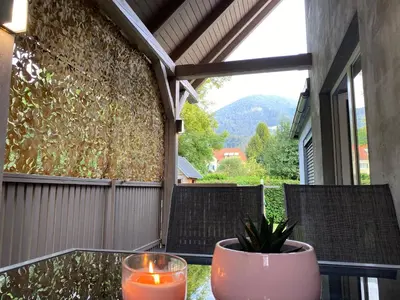 a table with two candles and two chairs on a patio at Apartma Mimi in Bohinj