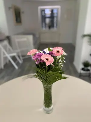 a vase filled with pink flowers on a table at Apartma Mimi in Bohinj