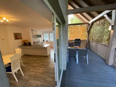 a balcony with a table and chairs and a kitchen at Apartma Mimi in Bohinj
