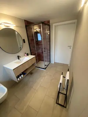 a bathroom with a sink and a mirror and a shower at Apartma Mimi in Bohinj