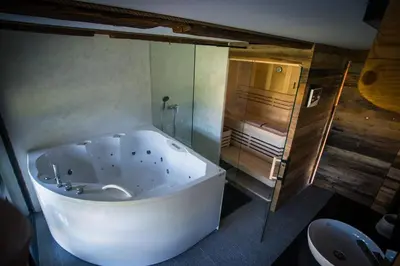 a large white tub in a bathroom with a shower at Hayrack Skok Mozirje in Mozirje
