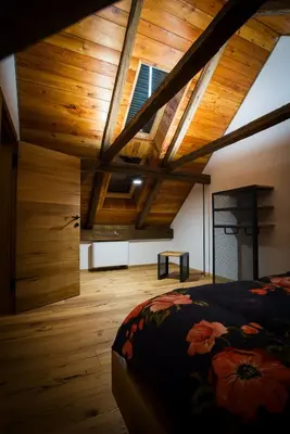 a bedroom with wooden ceilings and a bed in a room at Hayrack Skok Mozirje in Mozirje