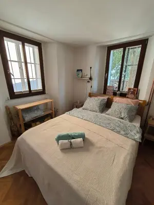 a bedroom with a large bed with two towels on it at Glasbeni atelje Tri ptičice in Kranj