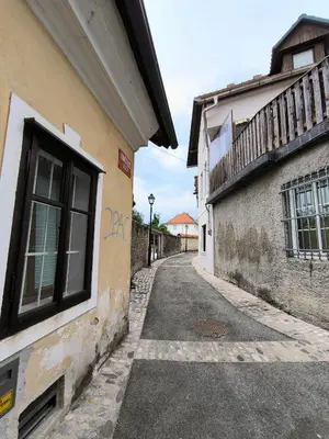 an alleyway between two buildings with a window at Glasbeni atelje Tri ptičice in Kranj