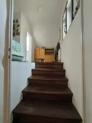 a staircase with wooden steps in a house at Glasbeni atelje Tri ptičice in Kranj