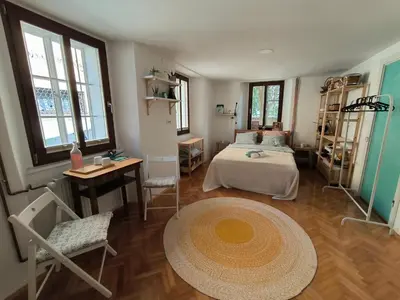 a bedroom with a bed and a table and chairs at Glasbeni atelje Tri ptičice in Kranj